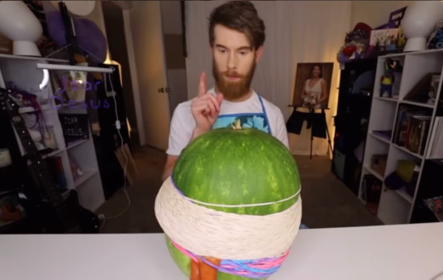 TikTok live of man putting rubberbands on a watermelon