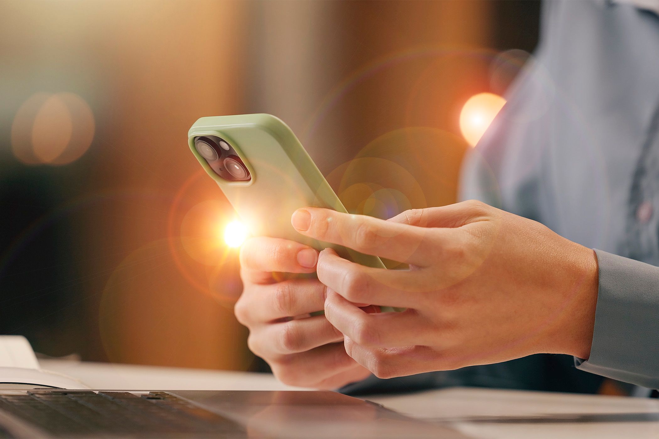 A person using a phone and a lens flare effect.